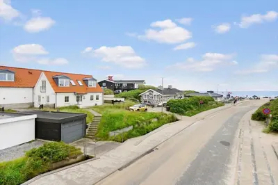 an empty street in a residential neighborhood with houses at BL1222-Blokhus-Strandvejen-13-B in Blokhus