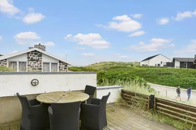 a patio with a table and chairs on a deck at BL1222-Blokhus-Strandvejen-13-B in Blokhus