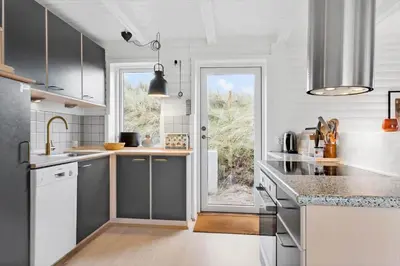 a kitchen with gray and white cabinets and a window at BL1314-Pandrup-Nordvej-11 in Pandrup