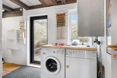 a laundry room with a washing machine and a window at BL1314-Pandrup-Nordvej-11 in Pandrup