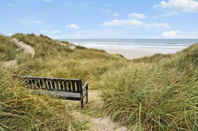 a bench sitting on a sandy beach near the ocean at BL1314-Pandrup-Nordvej-11 in Pandrup