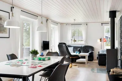 a living room with a table and chairs at BL1286-Saltum-Lyngsletten-4 in Saltum