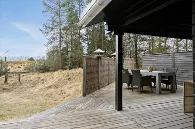 a patio with a table and chairs on a deck at BL969-Blokhus-Bregnehojvej-16 in Blokhus