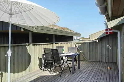a patio with a table and chairs and an umbrella at BL469-Pandrup-Hunetorp-Klitvej-179 in Pandrup
