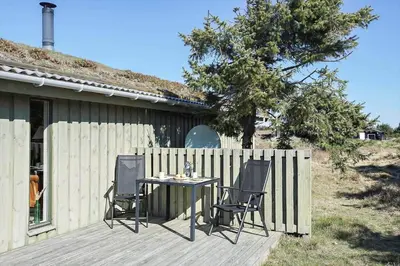 a table and chairs sitting on a wooden deck at BL469-Pandrup-Hunetorp-Klitvej-179 in Pandrup