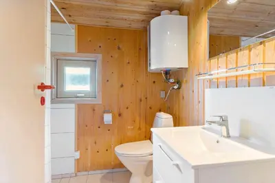 a bathroom with a toilet and a sink and a window at BL469-Pandrup-Hunetorp-Klitvej-179 in Pandrup