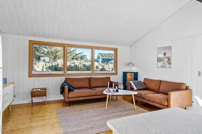 a living room with two couches and a table at BL1616-Blokhus-Moreavej-18 in Blokhus