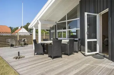 a deck with chairs and a table on a house at BL791-Blokhus-Paa-Bakken-3 in Blokhus