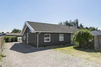 a brown house with a driveway in front of it at BL791-Blokhus-Paa-Bakken-3 in Blokhus