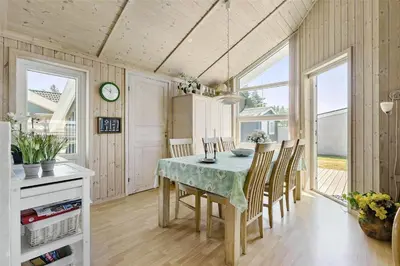 a kitchen and dining room with a table and chairs at BL791-Blokhus-Paa-Bakken-3 in Blokhus