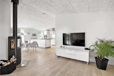 a living room with a fireplace and a flat screen tv at BL1134-Blokhus-Bloksbjerg-17-B in Blokhus