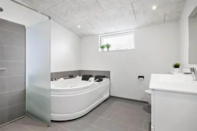 a bathroom with a tub and a toilet and a sink at BL1134-Blokhus-Bloksbjerg-17-B in Blokhus