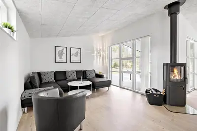 a living room with a couch and a fireplace at BL1134-Blokhus-Bloksbjerg-17-B in Blokhus