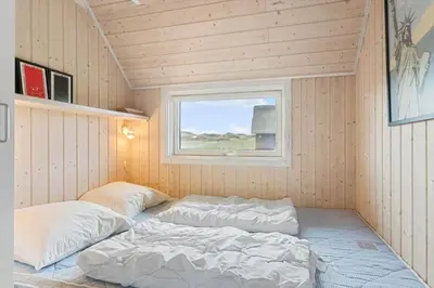 a room with two beds in a small room with a window at BL830-Pandrup-Bardehvalen-3 in Pandrup