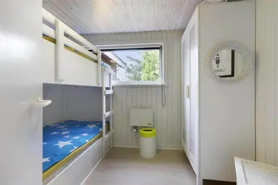 a small room with bunk beds and a window at BL1447-Blokhus-Skraavejen-11 in Blokhus