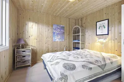 a bedroom with a bed and a wooden wall at BL1447-Blokhus-Skraavejen-11 in Blokhus