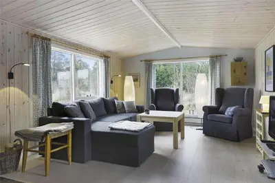a living room with a blue couch and chairs at BL1447-Blokhus-Skraavejen-11 in Blokhus