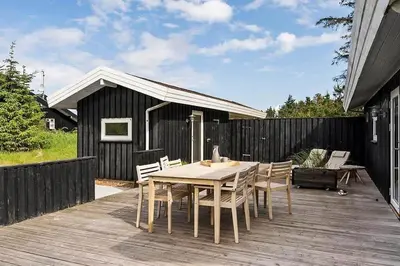 a wooden deck with a table and chairs on it at BL1654-Saltum-Ornebjergvej-11 in Saltum