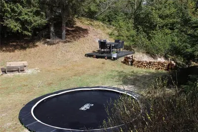 a backyard with a trampoline and a picnic table and a trampoline at BL1384-Blokhus-Kragebak-7 in Blokhus