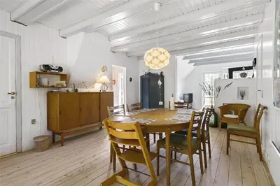 a dining room with a wooden table and chairs at BL1384-Blokhus-Kragebak-7 in Blokhus