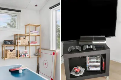 a living room with a tv and a table at BL1377-Blokhus-Valmuemarken-37 in Blokhus