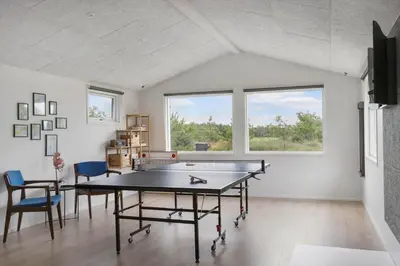 a room with a ping pong table and chairs at BL1377-Blokhus-Valmuemarken-37 in Blokhus