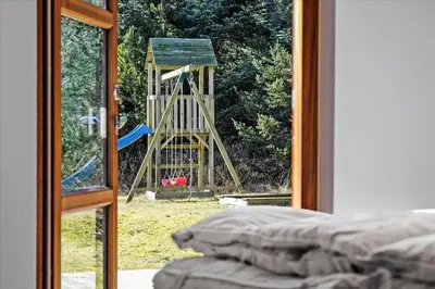 a view of a playground through a sliding glass door at BL451-Saltum-Trehoje-14 in Saltum