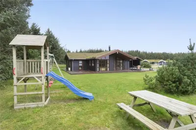 a playground with a slide and a bench and a house at BL451-Saltum-Trehoje-14 in Saltum