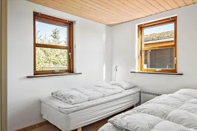 two beds in a white room with two windows at BL451-Saltum-Trehoje-14 in Saltum
