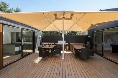 an umbrella on a deck with tables and chairs at BL1257-Saltum-Vesterhavs-Sletten-35 in Saltum