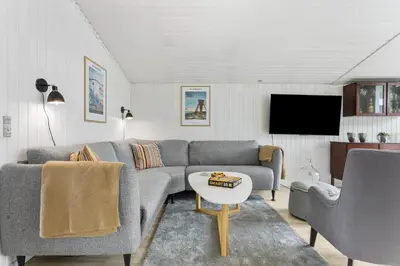 a living room with a couch and a tv at BL1218-Blokhus-Quintusvej-24 in Blokhus