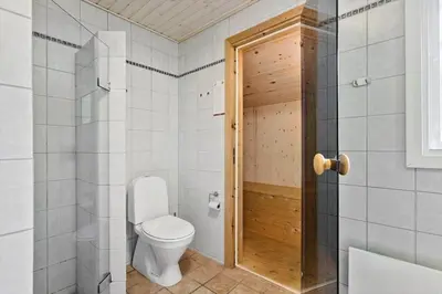 a bathroom with a toilet and a wooden door at BL1029-Pandrup-Rodhus-Skolevej-9 in Pandrup