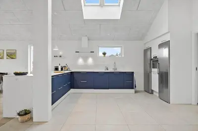 a kitchen with blue cabinets and a white ceiling at BL1355-Blokhus-Ribergaardsvej-24 in Blokhus