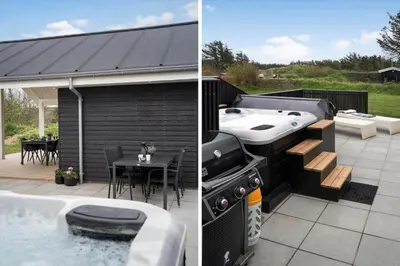 a patio with a grill and a barbecue with a table at BL1355-Blokhus-Ribergaardsvej-24 in Blokhus