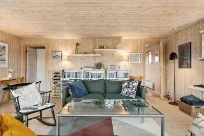a living room with a green couch and a glass table at BL709-Blokhus-Kr-Thomsensvej-5 in Blokhus
