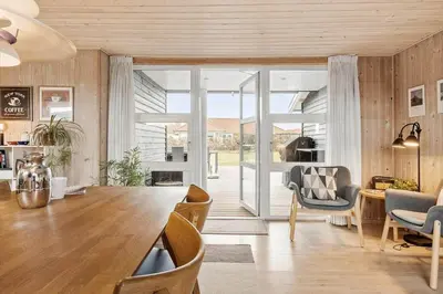 a living room with a large wooden table and chairs at BL709-Blokhus-Kr-Thomsensvej-5 in Blokhus
