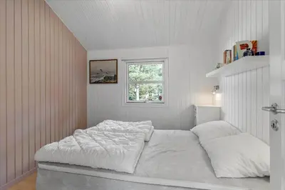 a white bedroom with a bed and a window at BL1727-Pandrup-Lunekrogen-16 in Pandrup