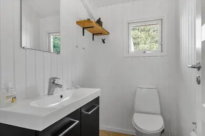a white bathroom with a sink and a toilet at BL1727-Pandrup-Lunekrogen-16 in Pandrup
