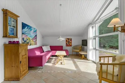 a living room with a pink couch and a window at BL1727-Pandrup-Lunekrogen-16 in Pandrup