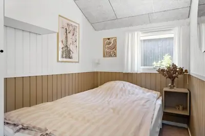 a bedroom with a bed and a window at BL1346-Blokhus-Septimusvej-19 in Blokhus