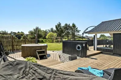 a wooden deck with a table and a gazebo at BL1346-Blokhus-Septimusvej-19 in Blokhus