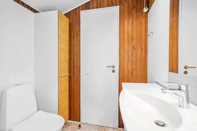 a bathroom with a sink and a toilet and a mirror at BL958-Blokhus-Havorns-Alle-14 in Blokhus