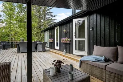 a patio with a couch and a table on a deck at BL958-Blokhus-Havorns-Alle-14 in Blokhus