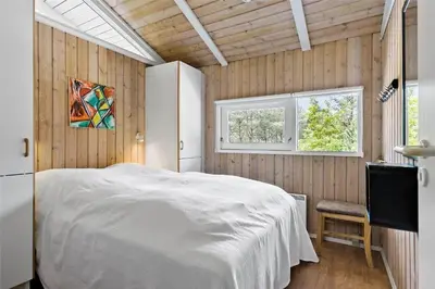 a bedroom with a white bed and two windows at BL1636-Saltum-Saltum-Strandvej-140 in Saltum