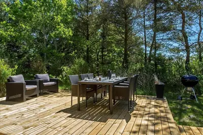 a patio with a table and chairs on a wooden deck at BL1636-Saltum-Saltum-Strandvej-140 in Saltum