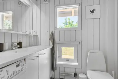 a white bathroom with a toilet and a sink at BL1636-Saltum-Saltum-Strandvej-140 in Saltum