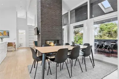 a dining room with a table and chairs and a fireplace at BL698-Blokhus-Kr-Thomsensvej-3 in Blokhus