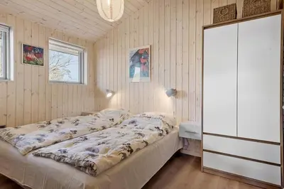 a bedroom with a bed and a dresser in it at BL1232-Blokhus-Pirupvejen-91 in Blokhus