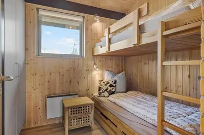 a bedroom with two bunk beds and a window at BL1232-Blokhus-Pirupvejen-91 in Blokhus