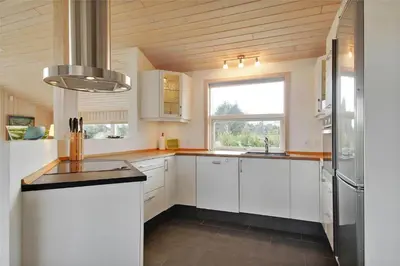 a kitchen with white cabinets and a large window at BL1299-Saltum-Bondagervej-44 in Saltum